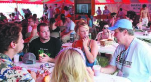 Steve Pearson, right, evangelism specialist for the Tennessee Baptist Convention, talks with some visitors to The Jesus Tent, a ministry of Tennessee Baptists during Bonnaroo, a camping music festival held in Manchester June 11-14. The ministry is the largest evangelistic effort of the Tennessee Baptist Convention. Photo by Connie Davis Bushey